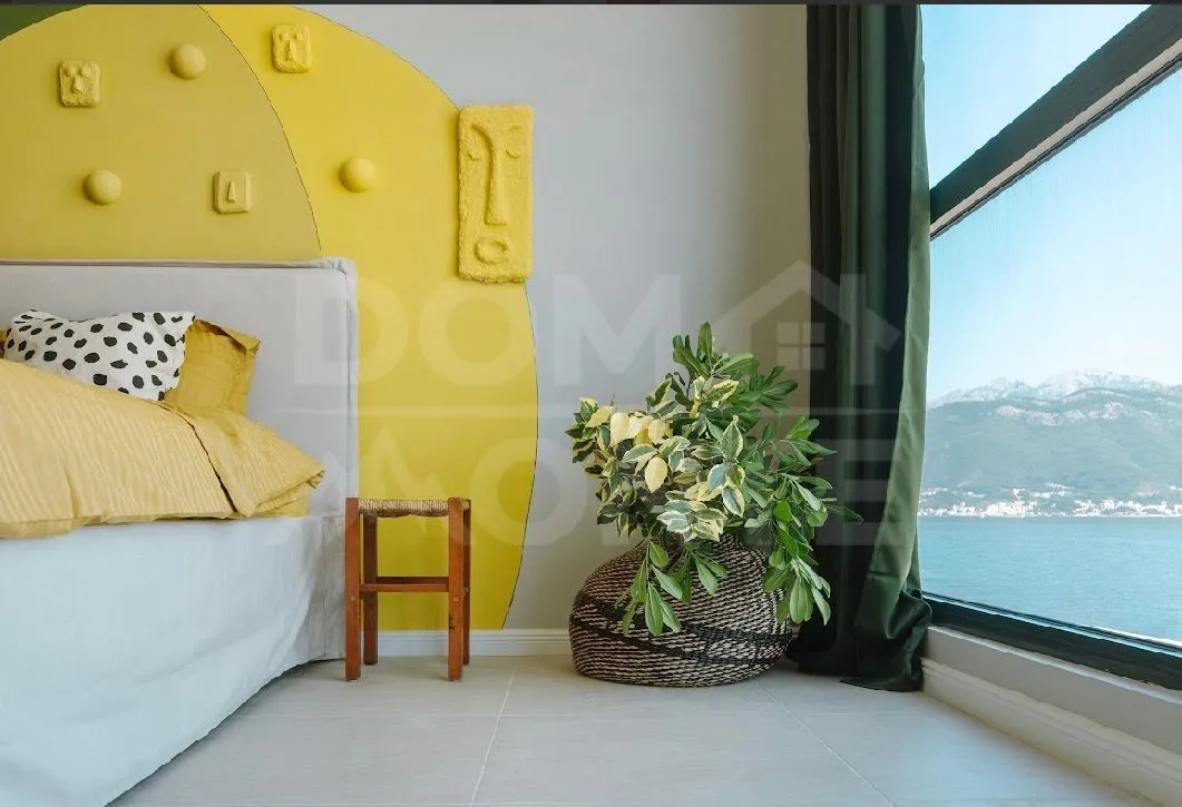 Modern bedroom with a large window and sea view.