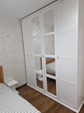 Spavaća soba sa velikim bijelim ormarom sa ogledalima i bračnim krevetom. - image 5