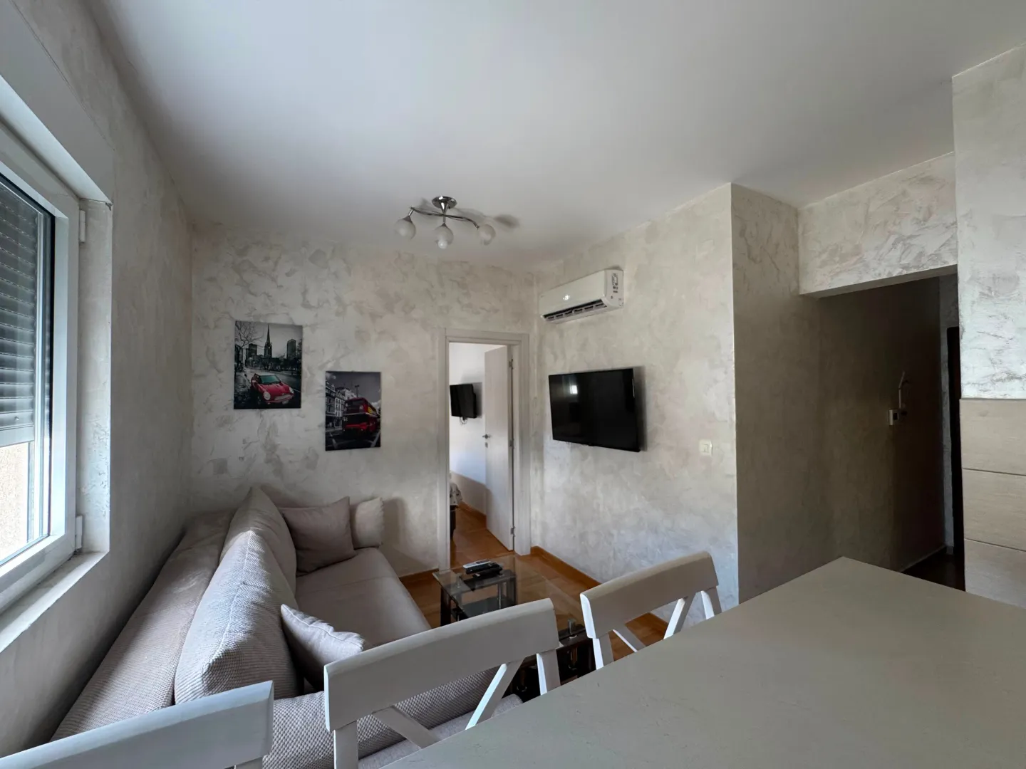 Bright living room with a comfortable sofa and wall-mounted TV.