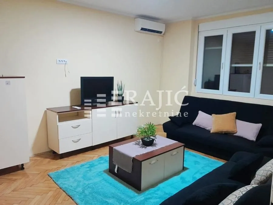 Living room with sofa, television, and coffee table.
