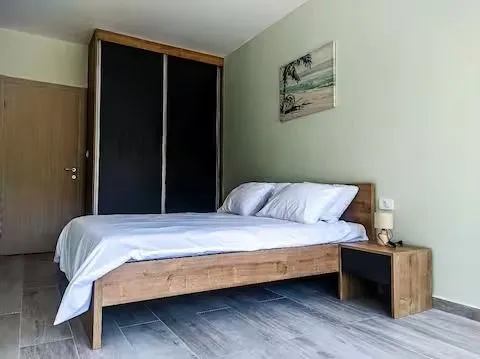 Furnished bedroom with a double bed, wardrobe, and nightstand. - image 15