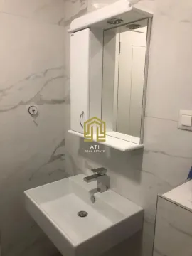 Modern bathroom with a white sink and a mirrored cabinet. - image 18