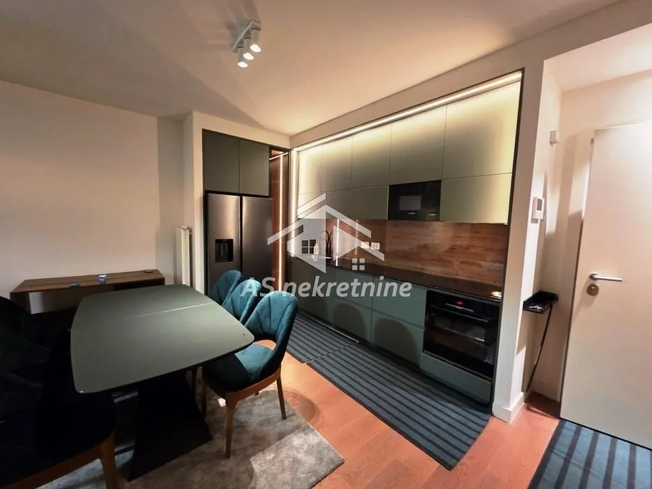 Modern kitchen with dark cabinets and a dining table.