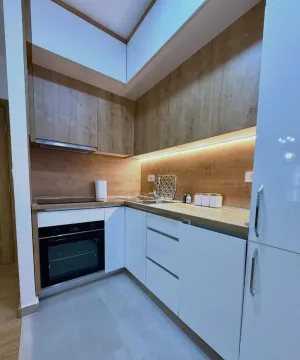 Modern kitchen with wooden elements and built-in appliances. - image 7