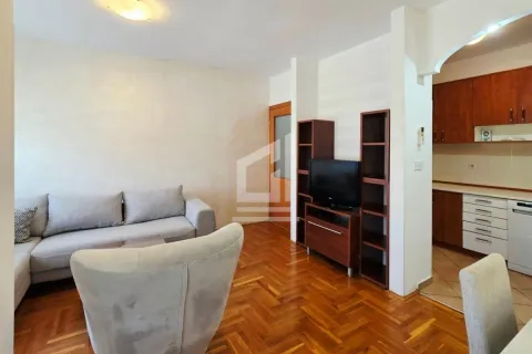 Living room with a sofa and television, with a view of part of the kitchen. - image 4