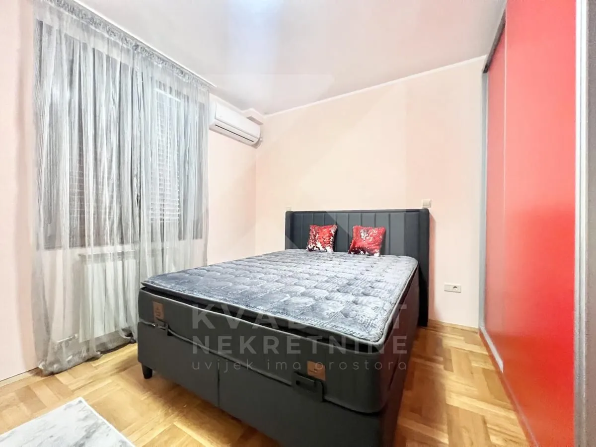 Spavaća soba sa bračnim krevetom, klima-uređajem i ugradnim garderoberom.