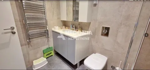 Savremeno opremljeno kupatilo sa umivaonikom, WC šoljom i peškirašem. - image 16
