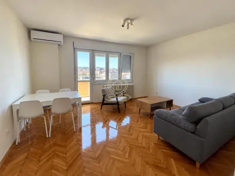 Living room with a sofa, dining table, and access to the balcony. - image 2