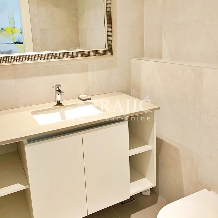 Modernly equipped bathroom with a vanity sink and a large mirror.