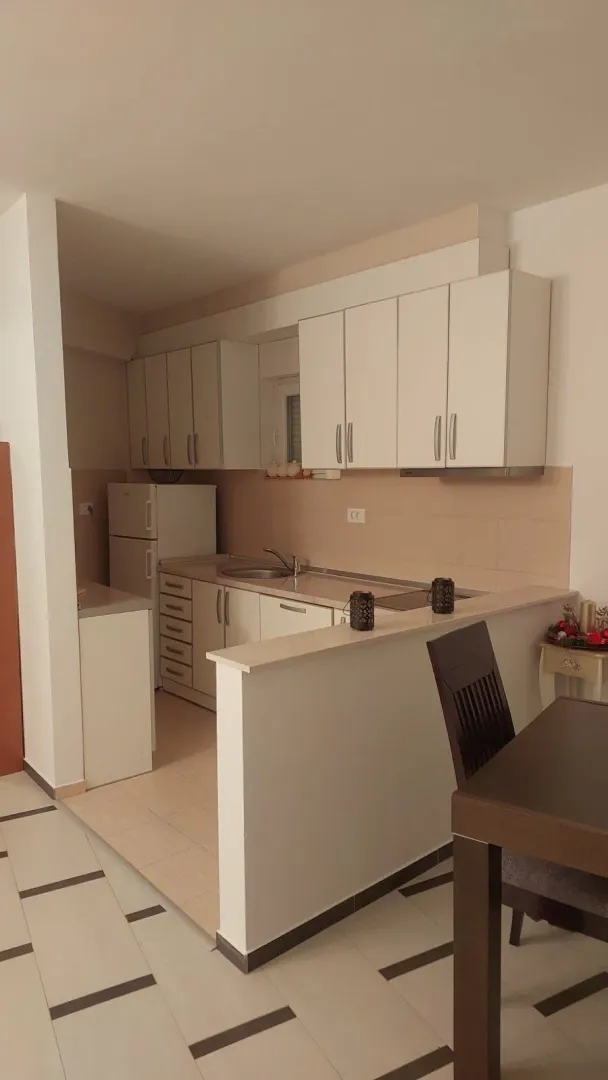 Smaller kitchen with white cabinetry and a breakfast bar connected to the dining area.