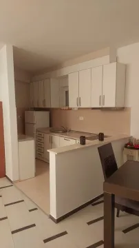 Smaller kitchen with white cabinetry and a breakfast bar connected to the dining area. - image 12