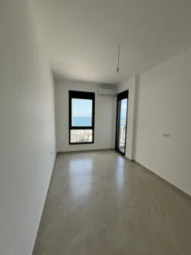 An empty, bright room with a window offering a sea view. - image 5