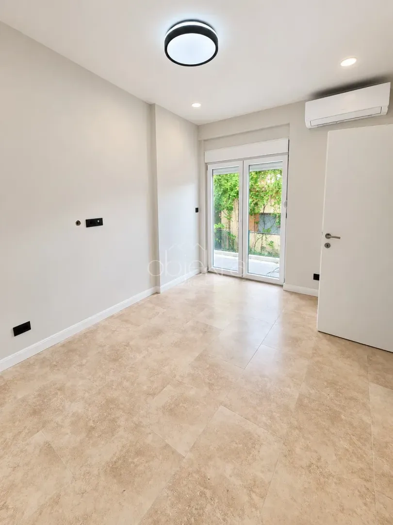 Empty room with tiled floor and air conditioning unit.