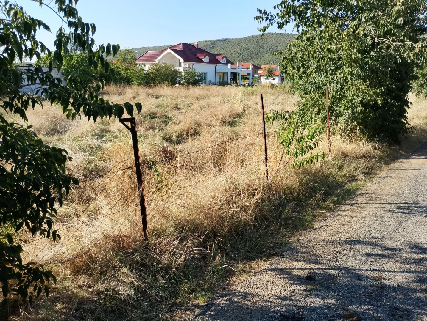 Pogled na plac i porodičnu kuću sa putem u prednjem dijelu.