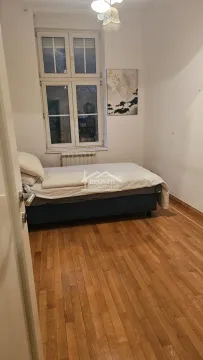Manja spavaća soba sa krevetom i drvenim podom. - image 13