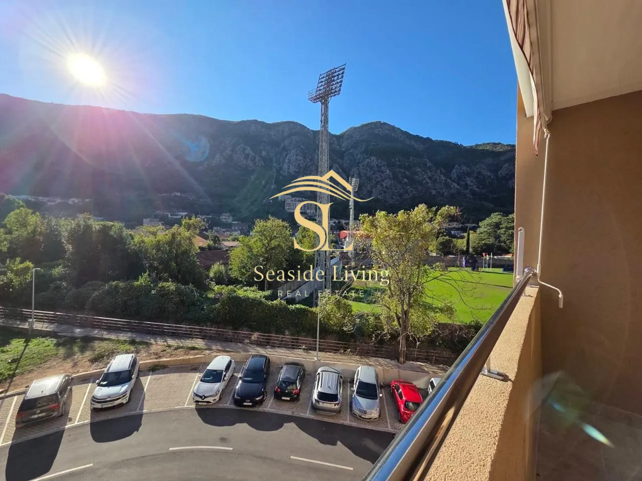 View from the terrace overlooking surrounding greenery, hills, and parking.
