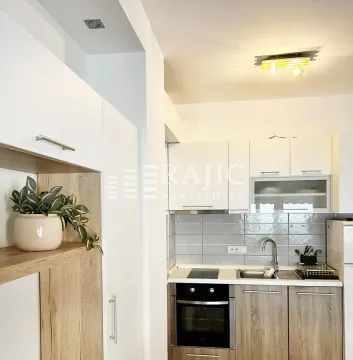 Modern white kitchen with wooden details and built-in appliances. - image 4
