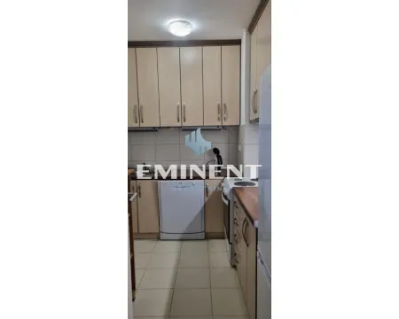 Smaller kitchen with wooden cabinets and built-in appliances. - image 5