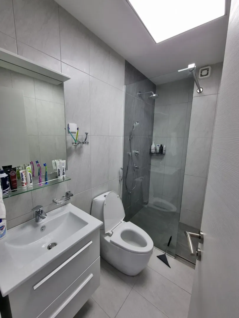 Savremeno opremljeno kupatilo sa umivaonikom, WC šoljom i tuš kabinom.