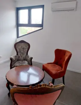 Bright living room with seating furniture and an air conditioner. - image 6