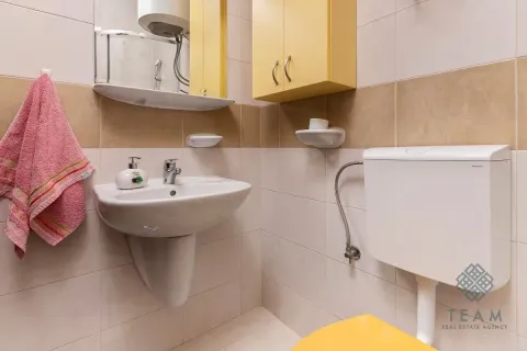 Smaller bathroom with a washbasin, mirror, and toilet. - image 14