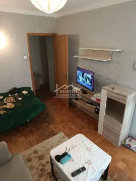 Living room with a bed, TV, and wooden furniture. - image 4