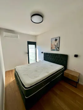 Spavaća soba sa bračnim krevetom, drvenim podom i klima uređajem. - image 6