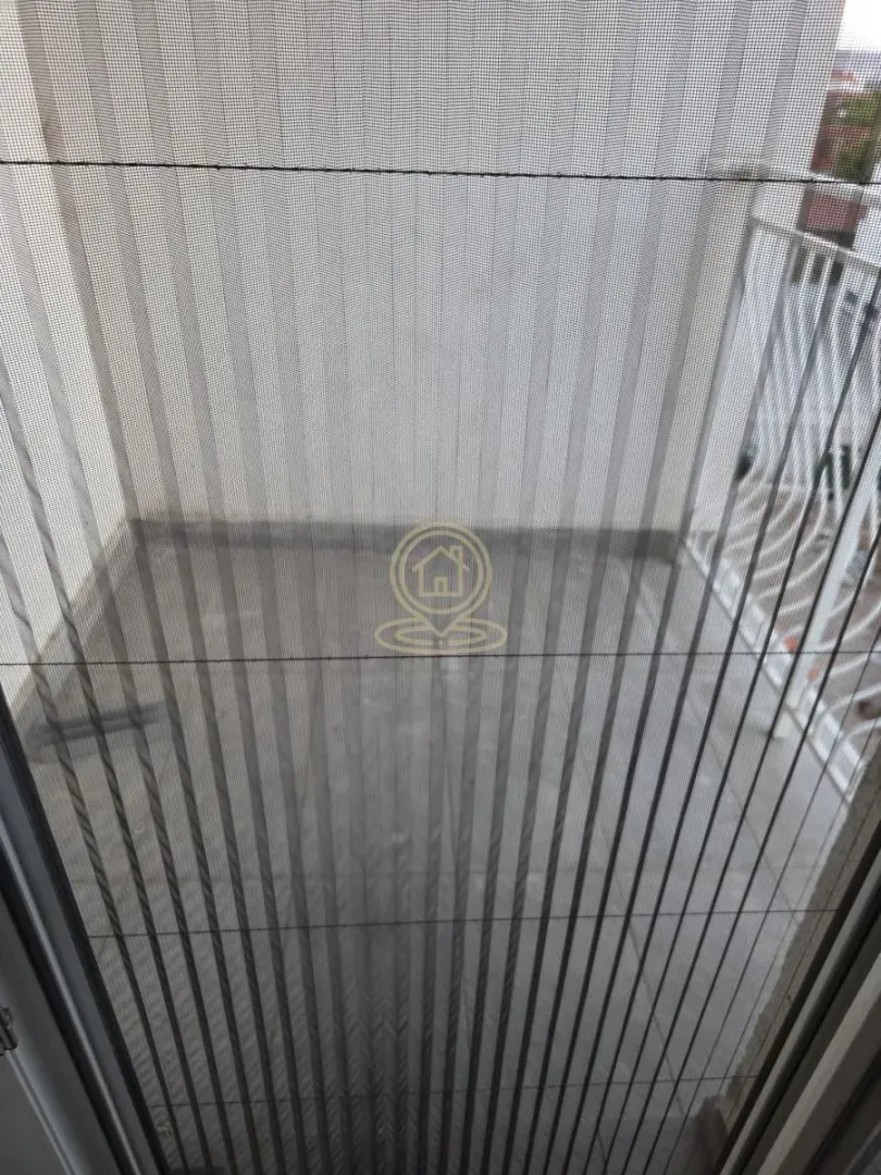 Pogled na terasu kroz zaštitnu mrežicu na vratima.