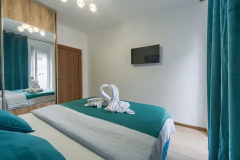 Bedroom with a double bed, mirrored wardrobe and a wall-mounted TV. - image 11