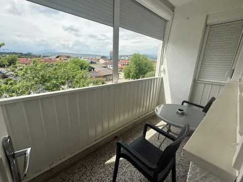 Enclosed balcony with seating furniture and city view. - image 9