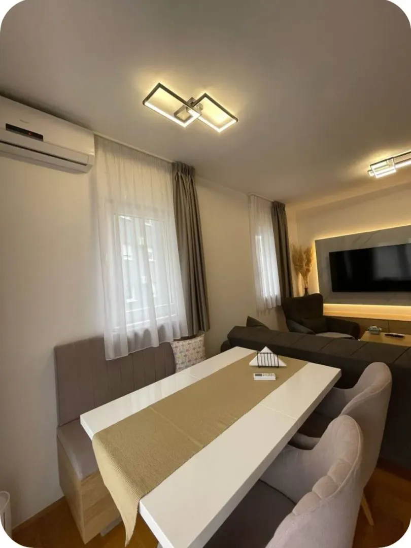 Living room with a dining table, sofa seating, and a TV.