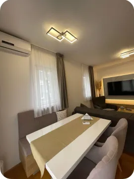 Living room with a dining table, sofa seating, and a TV. - image 15