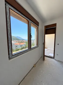 Nezavršena prostorija sa velikim prozorom i pogledom na grad i more. - image 6