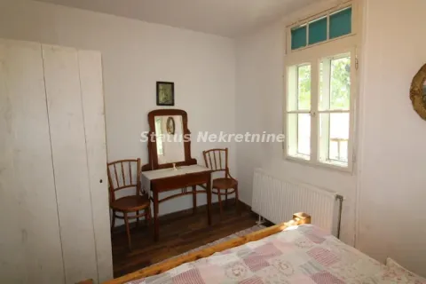 Modestly furnished bedroom with a bed, wooden furniture, and a window. - image 9