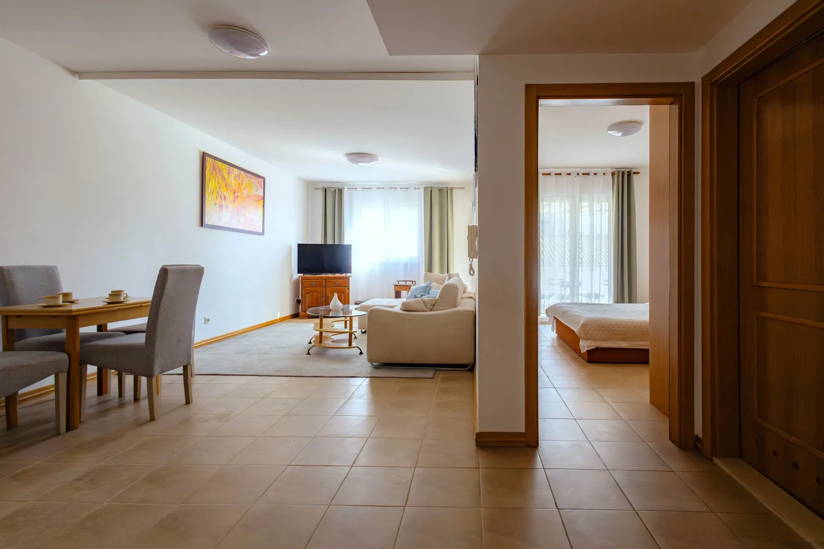 Spacious living room with a dining area and a view into the bedroom.