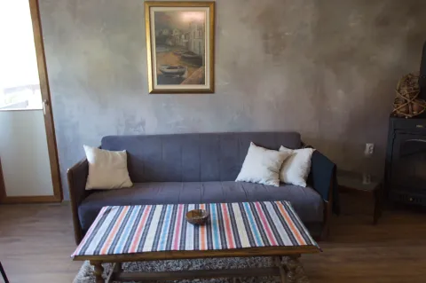Living room with a grey sofa, coffee table, and a painting on the wall. - image 3