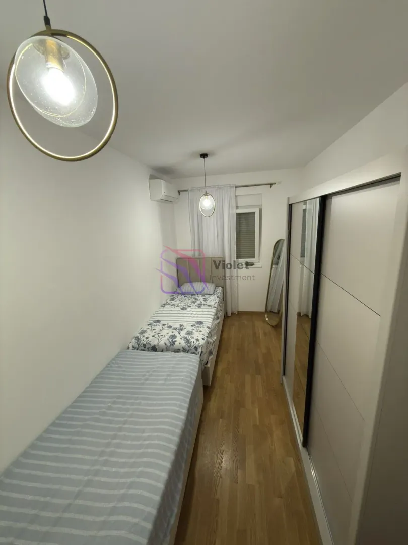 Small bedroom with two beds and a wardrobe.