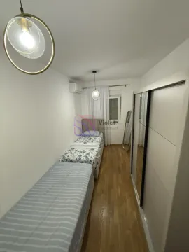 Small bedroom with two beds and a wardrobe. - image 5