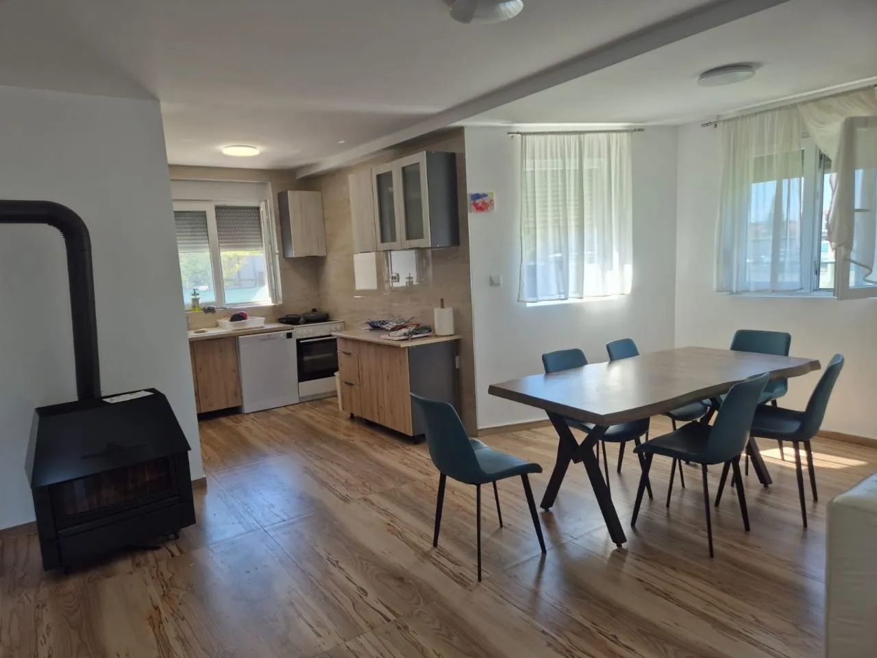 Open space area with a kitchen, dining area, and wood-burning stove.