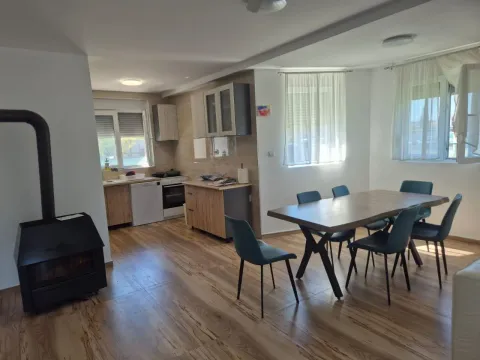 Open space area with a kitchen, dining area, and wood-burning stove. - image 13