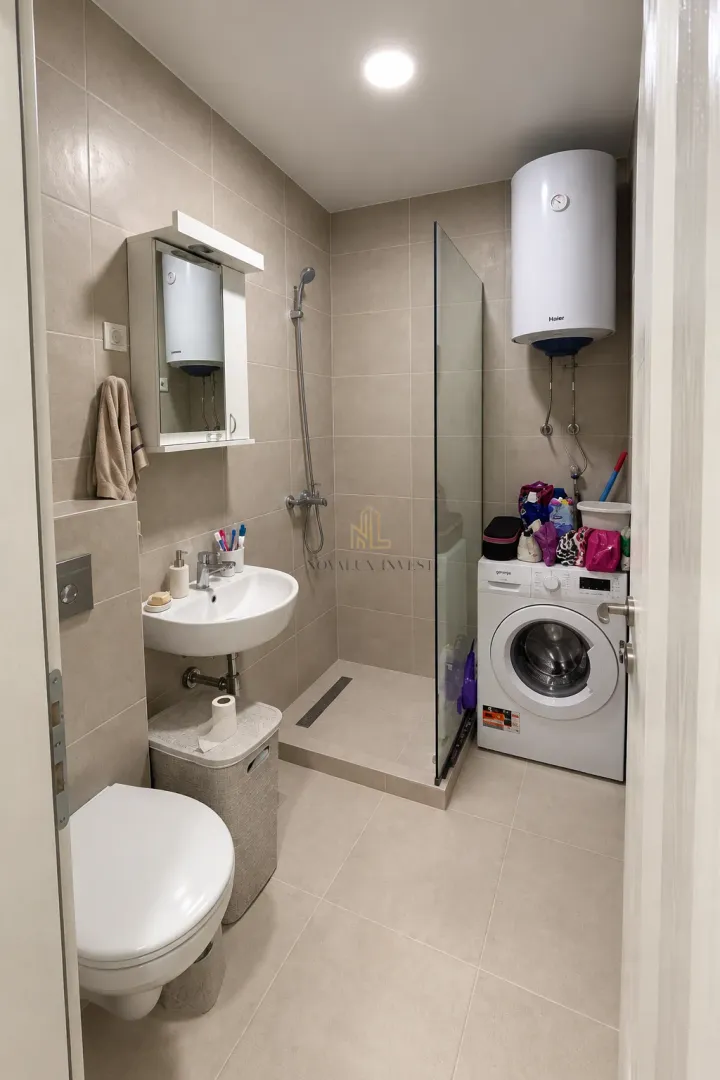 Compact bathroom with a walk-in shower and washing machine.