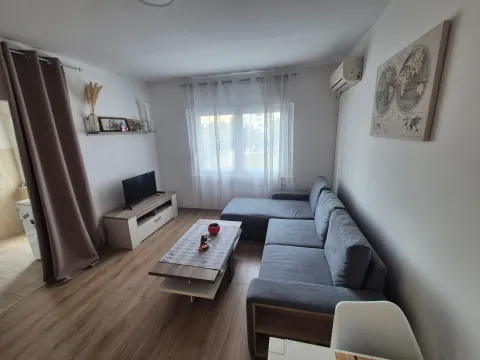 Living room with a sectional sofa, TV cabinet, and coffee table. - image 2