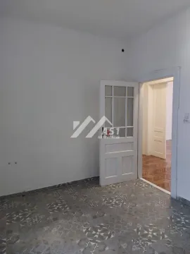 Prazna prostorija sa popločanim podom i belim vratima. - image 6