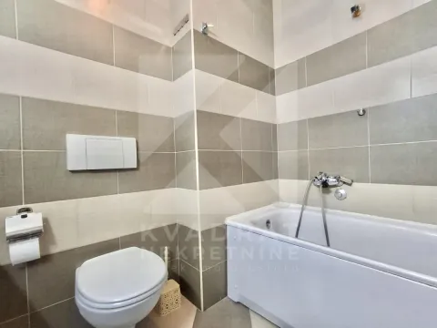Kupatilo opremljeno kadom, wc šoljom i zidnim pločicama. - image 6