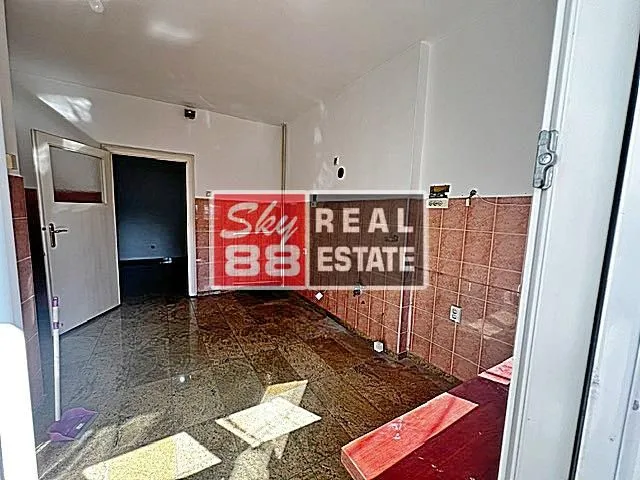 Empty kitchen with wall tiles and a marble floor.