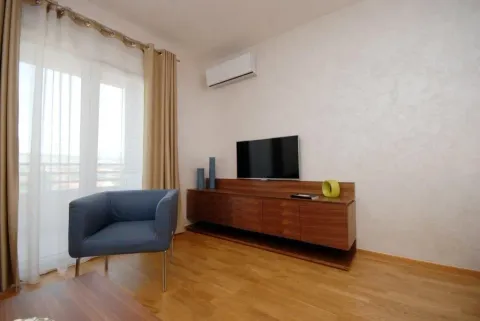 Living room with a TV stand and a blue armchair. - image 3