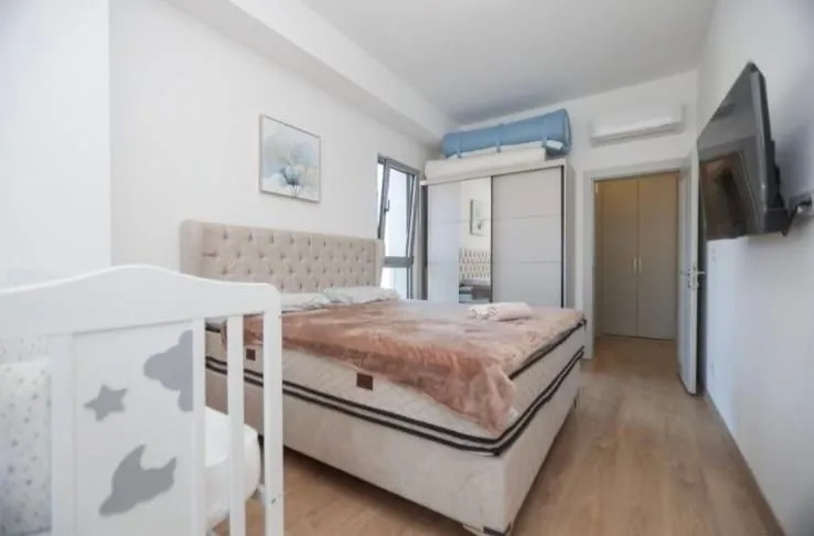 Bright bedroom with a double bed, crib, and wardrobe.