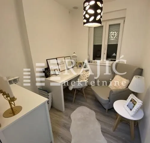Small room arranged as a study corner with a desk and an armchair.
