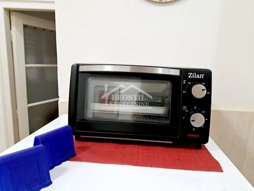 Manja električna rerna na kuhinjskoj radnoj površini.