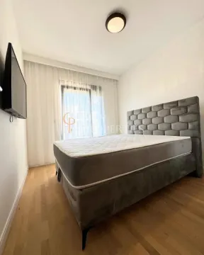 Bedroom with a double bed, wooden flooring, and a wall-mounted TV. - image 6